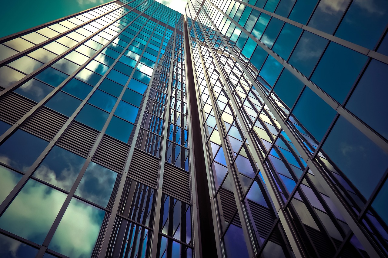 clouds reflecting on skyscraper glass windows 